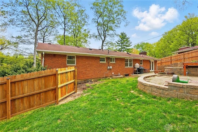 back of house with a patio, brick siding, fence, and a lawn