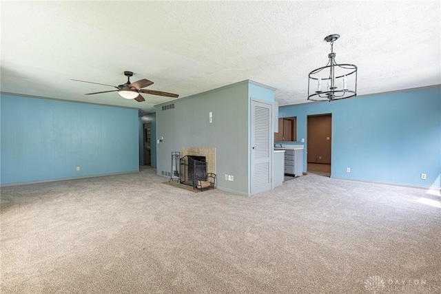 unfurnished living room with visible vents, baseboards, carpet floors, a fireplace, and ceiling fan with notable chandelier