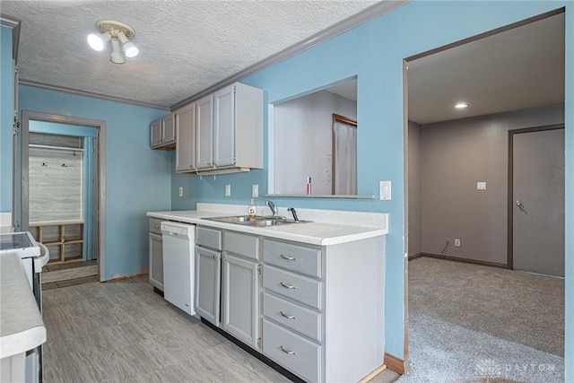 kitchen with light countertops, dishwasher, a sink, baseboards, and a textured ceiling