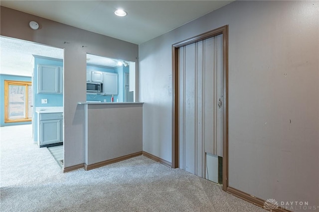 spare room with light carpet and baseboards