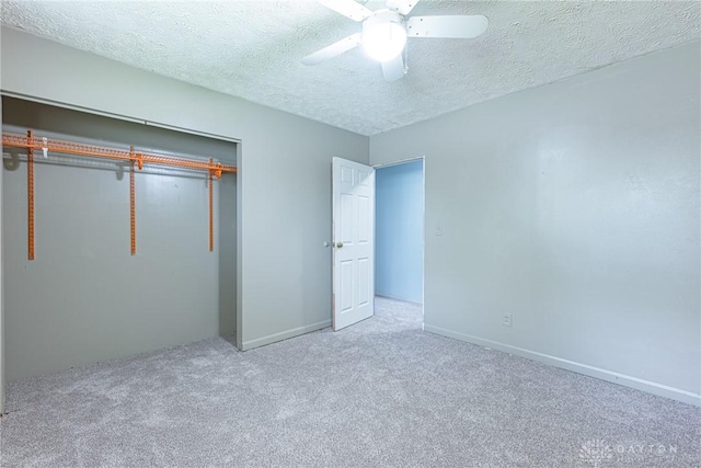 unfurnished bedroom with carpet floors, a closet, baseboards, a ceiling fan, and a textured ceiling