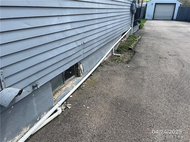 exterior details featuring fence and aphalt driveway