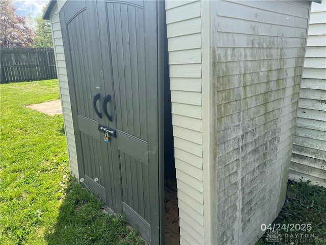 view of shed featuring fence