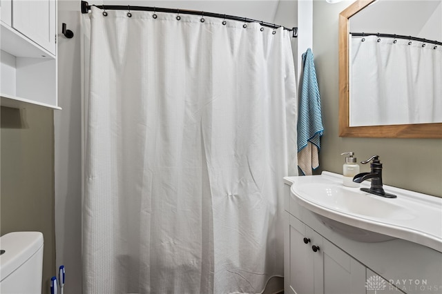 full bathroom featuring curtained shower, vanity, and toilet