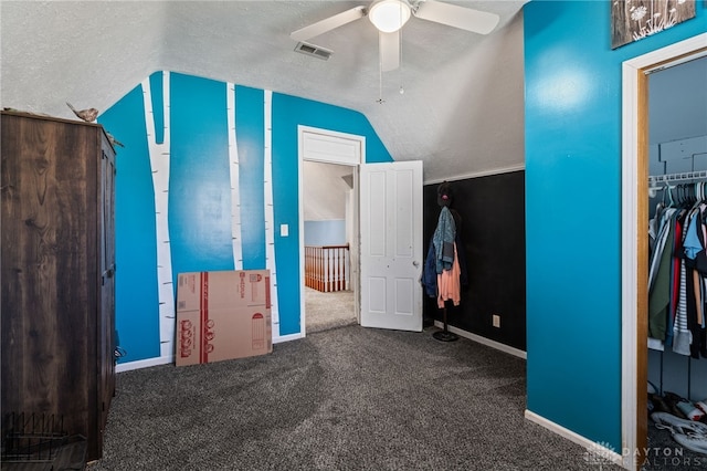 unfurnished bedroom with carpet floors, visible vents, baseboards, ceiling fan, and vaulted ceiling