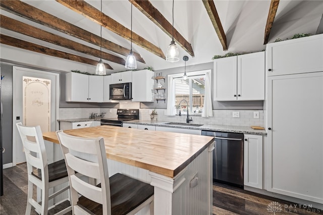kitchen featuring wood counters, backsplash, stainless steel appliances, and a sink