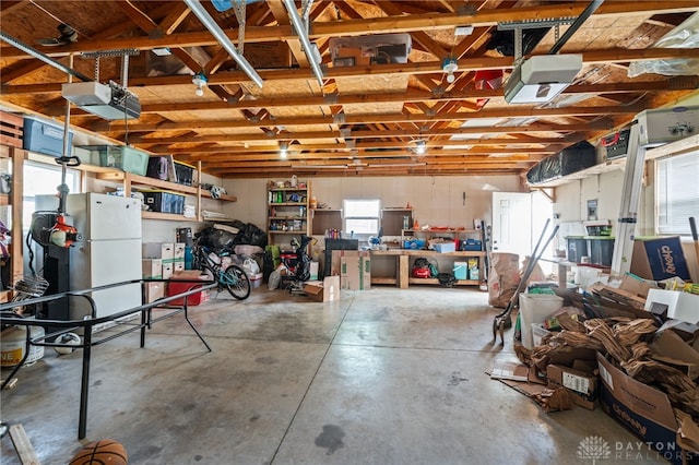 garage featuring freestanding refrigerator and a garage door opener
