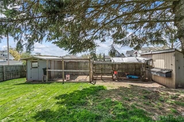 view of yard featuring exterior structure, a storage shed, an outbuilding, and a fenced backyard