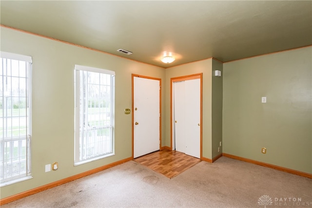 entryway featuring a healthy amount of sunlight, visible vents, and light carpet