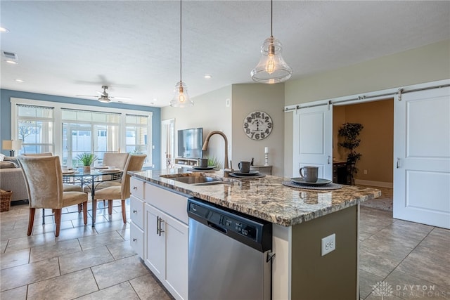kitchen with a sink, a barn door, a ceiling fan, stainless steel dishwasher, and open floor plan