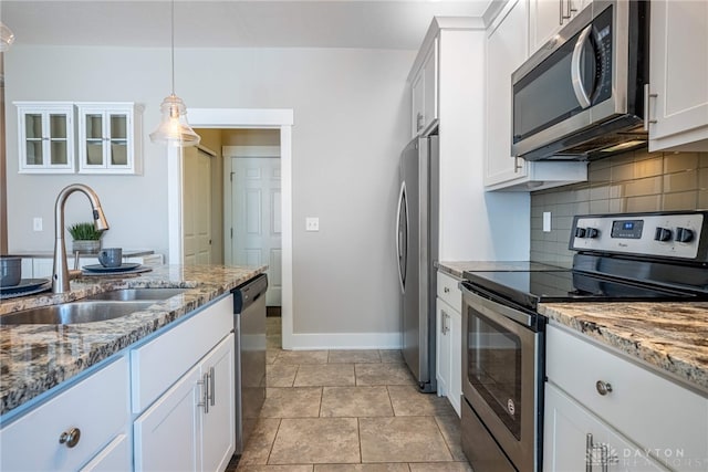 kitchen featuring white cabinetry, appliances with stainless steel finishes, decorative backsplash, and a sink