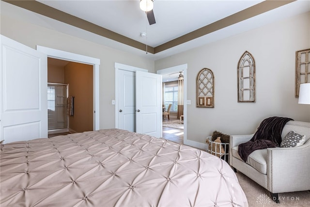 bedroom featuring ceiling fan, ensuite bath, and baseboards
