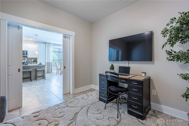 office space with baseboards and light tile patterned floors