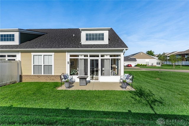 rear view of property featuring a patio, brick siding, a shingled roof, and a yard