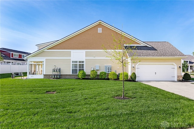 view of front of home with concrete driveway, a front yard, and a garage