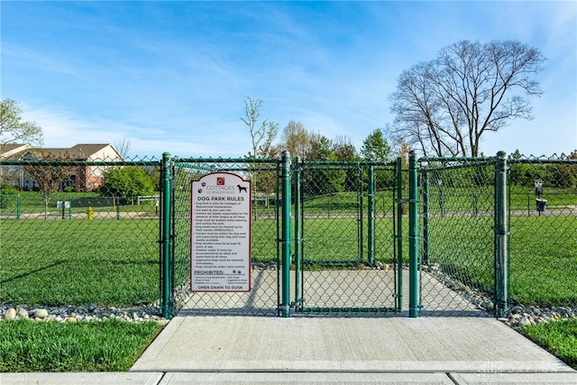 view of gate featuring fence and a yard