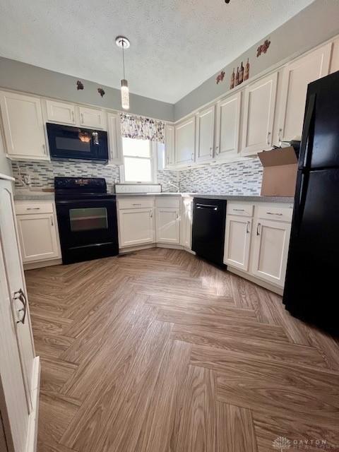 1331 Malden Ave, Springfield, OH 45504 - kitchen with black appliances, white cabinetry, decorative backsplash, and light countertops