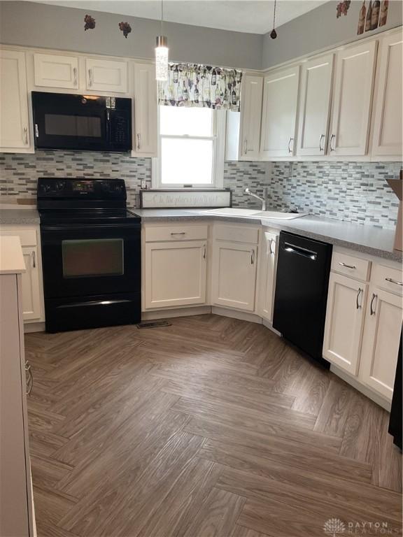 1331 Malden Ave, Springfield, OH 45504 - kitchen with black appliances, white cabinets, and decorative backsplash