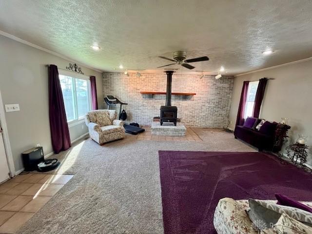 1331 Malden Ave, Springfield, OH 45504 - carpeted living room with tile patterned floors, a wood stove, a ceiling fan, a textured ceiling, and crown molding