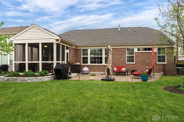 rear view of house featuring brick siding, a yard, and a patio area