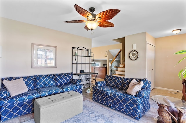 living room featuring stairway, visible vents, and a ceiling fan