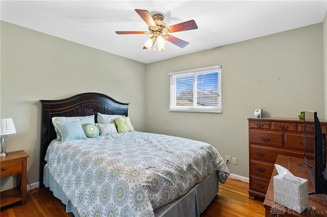 bedroom with baseboards, wood finished floors, and ceiling fan