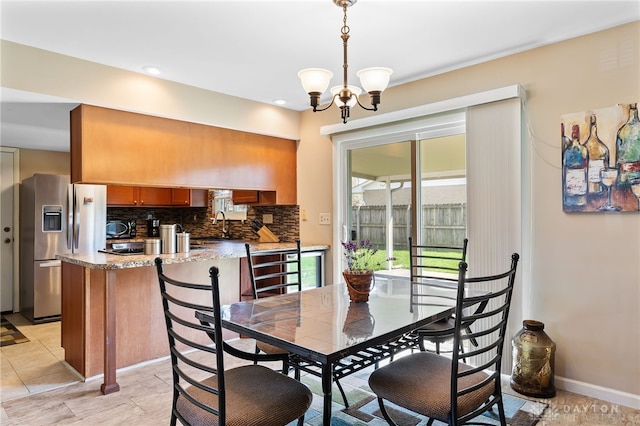 dining area with a chandelier and baseboards