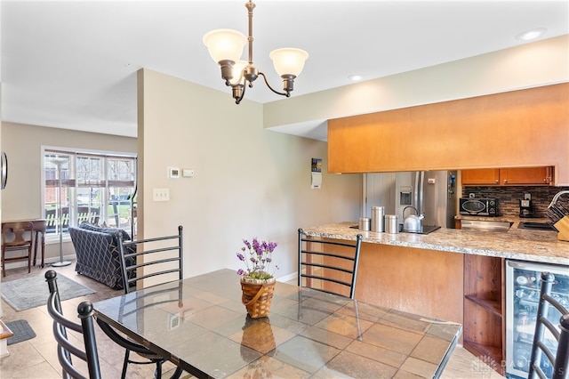 dining area with baseboards, beverage cooler, a notable chandelier, and recessed lighting