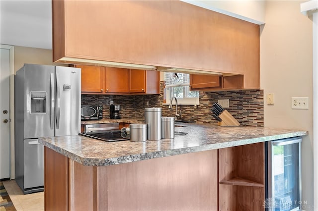 kitchen with a sink, decorative backsplash, stainless steel fridge, wine cooler, and a peninsula