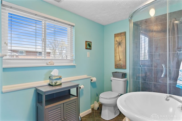 full bath with tile patterned floors, a textured ceiling, toilet, and plenty of natural light