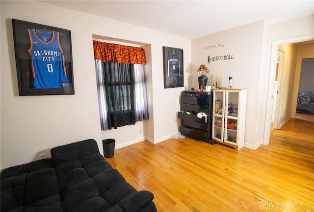living area with baseboards and wood finished floors