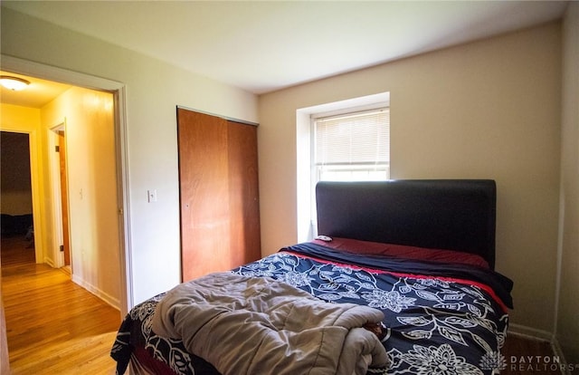 bedroom with wood finished floors and a closet