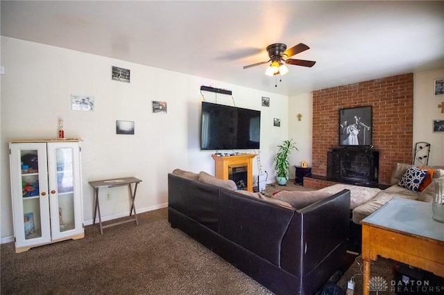 living room featuring a ceiling fan, carpet flooring, baseboards, and a fireplace