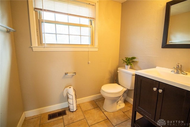 bathroom with visible vents, toilet, vanity, and baseboards