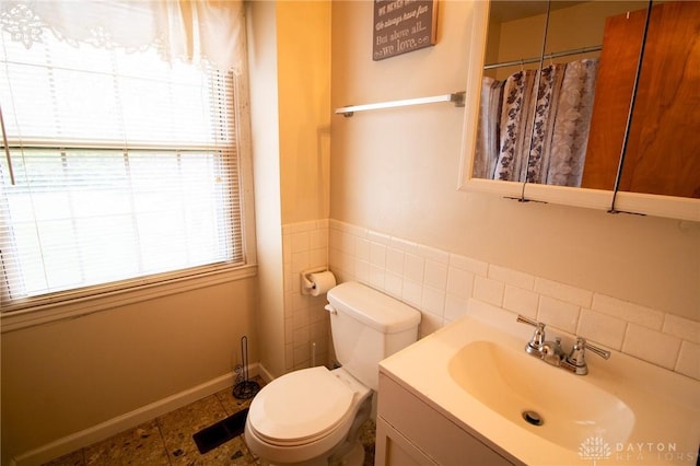 bathroom with wainscoting, tile walls, a shower with shower curtain, toilet, and vanity