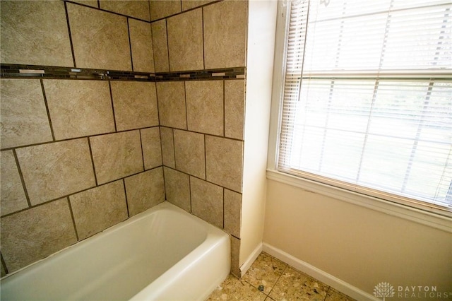 bathroom with walk in shower, tile patterned flooring, a washtub, and baseboards