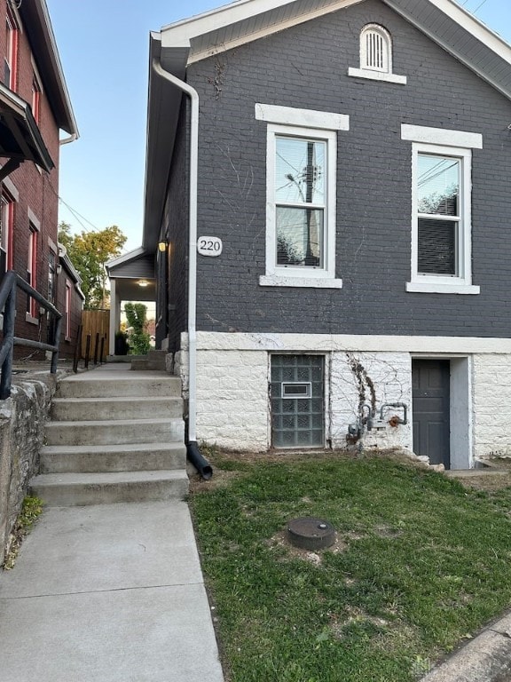 view of front of house featuring a front yard and brick siding