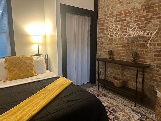 bedroom featuring brick wall