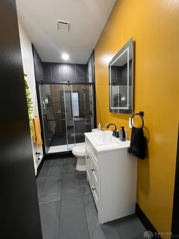bathroom featuring a shower stall, marble finish floor, toilet, vanity, and visible vents