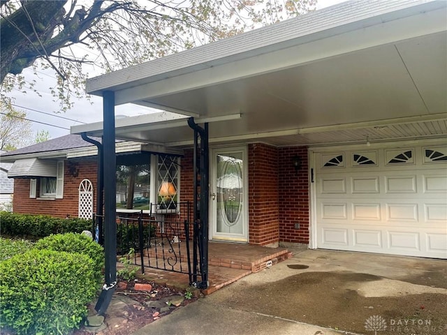 doorway to property featuring driveway, an attached garage, a porch, and brick siding