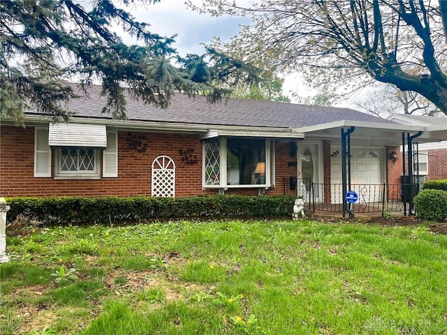 ranch-style house with a front lawn, an attached garage, and brick siding