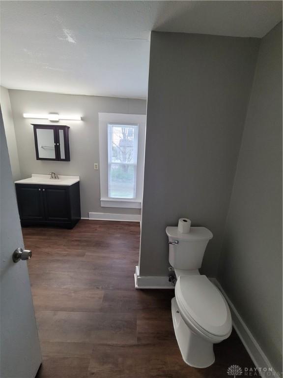 66 Barnett St Unit 64, Dayton, OH 45402 - bathroom with toilet, baseboards, wood finished floors, and vanity