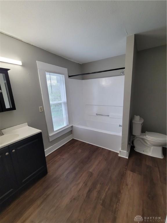 66 Barnett St Unit 64, Dayton, OH 45402 - full bath with toilet, wood finished floors, baseboards, vanity, and washtub / shower combination
