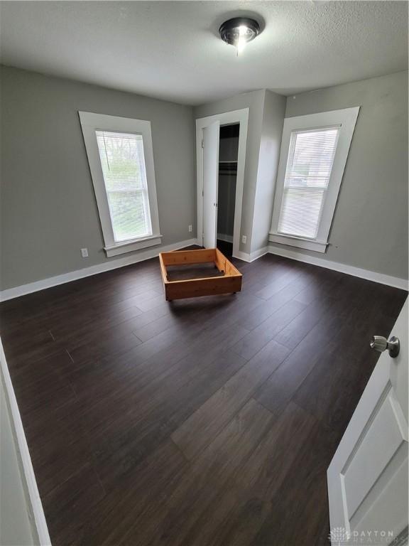 66 Barnett St Unit 64, Dayton, OH 45402 - unfurnished bedroom with dark wood-style flooring, baseboards, and a closet