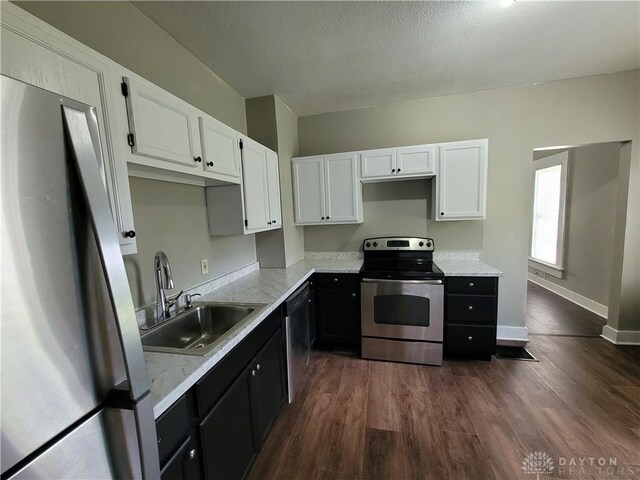 66 Barnett St Unit 64, Dayton, OH 45402 - kitchen featuring appliances with stainless steel finishes, white cabinets, dark cabinets, a sink, and dark wood-style flooring