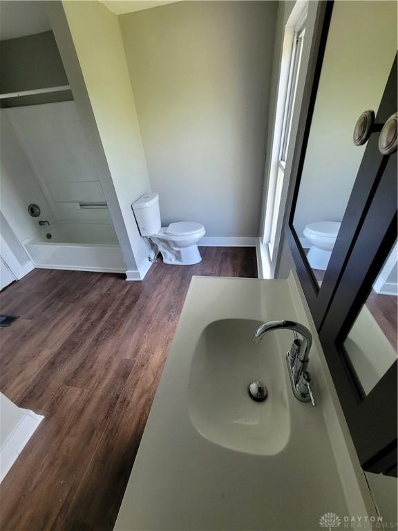 66 Barnett St Unit 64, Dayton, OH 45402 - bathroom featuring a sink, toilet, wood finished floors, baseboards, and a shower
