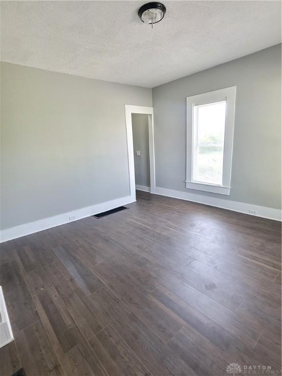 66 Barnett St Unit 64, Dayton, OH 45402 - empty room with dark wood-style flooring, baseboards, and a textured ceiling