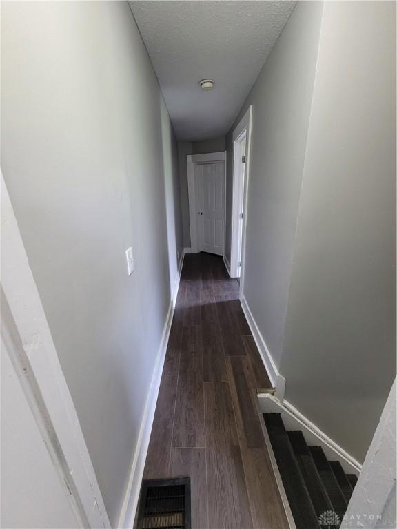 66 Barnett St Unit 64, Dayton, OH 45402 - hallway with dark wood-style flooring, baseboards, and a textured ceiling