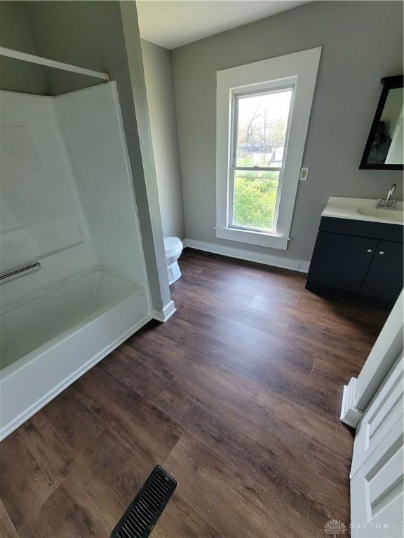 66 Barnett St Unit 64, Dayton, OH 45402 - full bath with toilet, vanity, wood finished floors, baseboards, and  shower combination