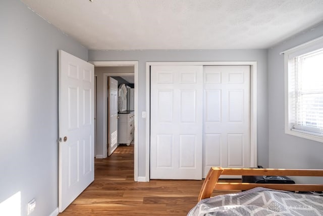bedroom featuring a closet, light wood-style flooring, and baseboards